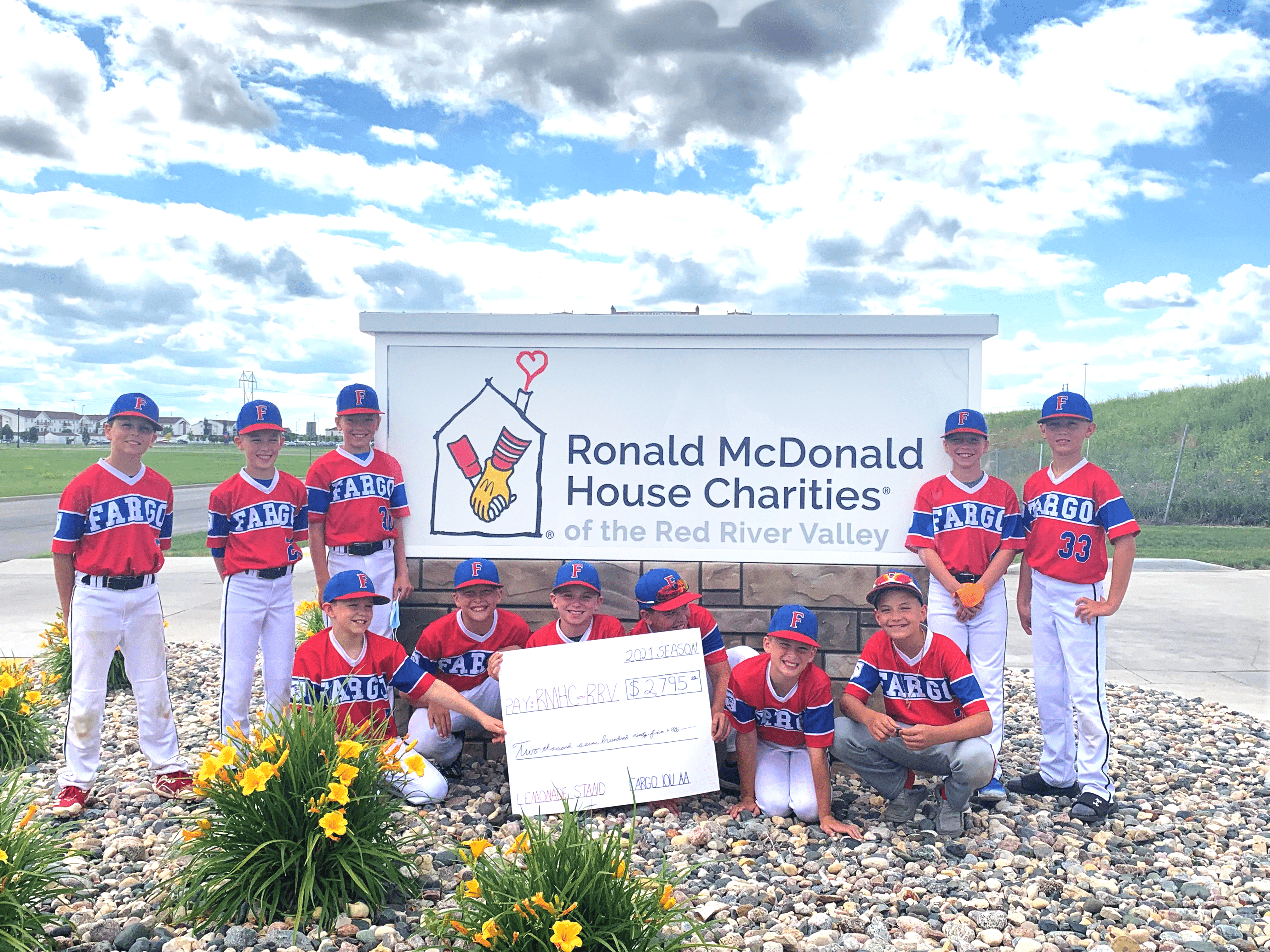 Youth baseball team presenting a check from a lemonade stand fundraiser