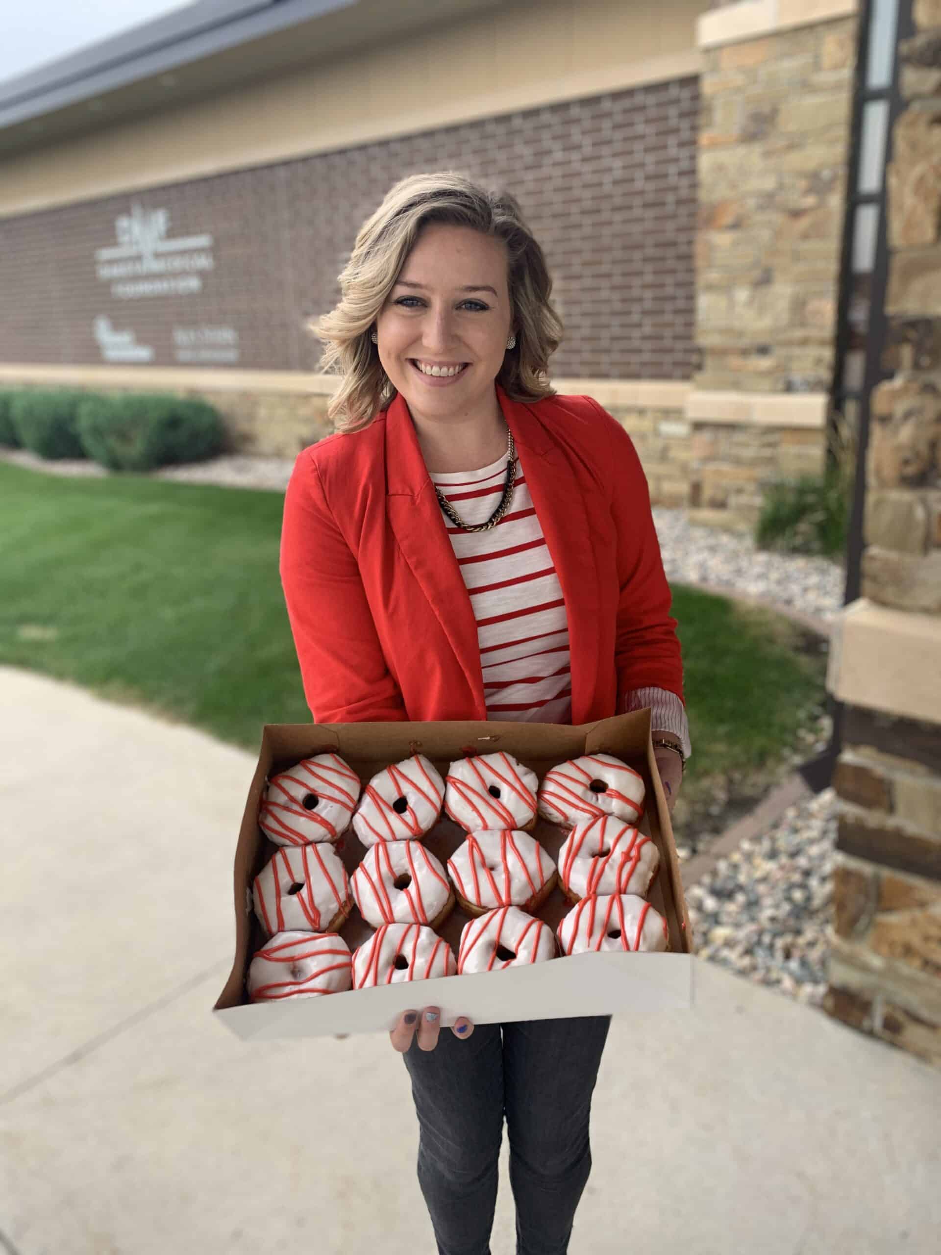 woman holding striped donuts