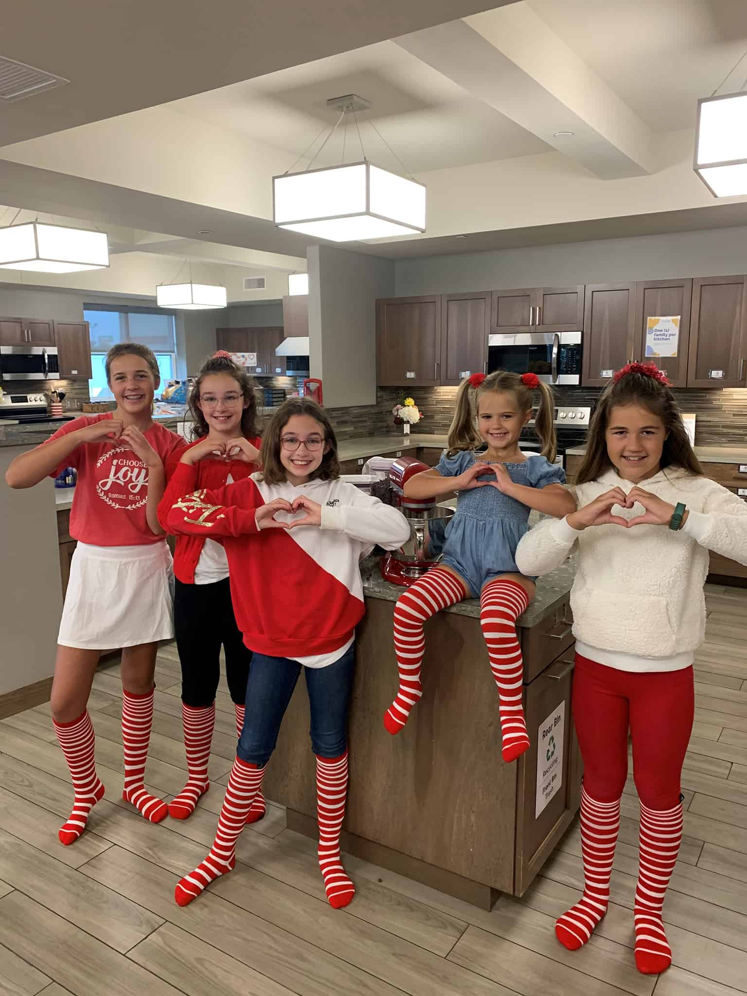 Youth volunteers in the kitchen wearing striped socks #forRMHC